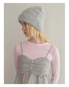 Detail of soft grey alpaca wool knit beanie paired with a textured plaid strap dress