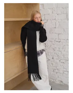 Nahaufnahme des schwarzen Schals aus Alpakawolle mit weichen Fransen und Stricktextur
