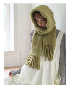 Detail of grass green alpaca wool hooded scarf featuring decorative fringe tassels