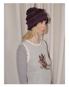 Détail du bonnet en tricot rayé Y2K avec texture à volants et pull motif chat mignon