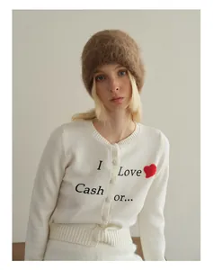 Detail of white knit cardigan with heart embroidery and brown fuzzy alpaca wool beanie