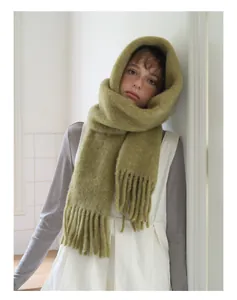 Close-up of soft mustard green alpaca wool scarf with fluffy texture and long tassels
