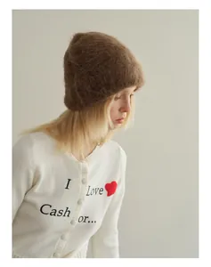 Detail view of brown alpaca knit beanie paired with a vintage slogan cardigan