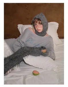 Detalle de pasamontañas de lana y bufanda de flecos con sudadera gris combinada