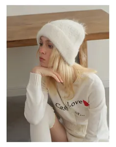 Detail of soft white alpaca knit beanie with matching cardigan and heart embroidery