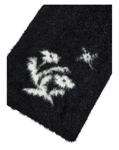 Détail d'écharpe en fausse fourrure noire avec maille duveteuse et motif jacquard blanc