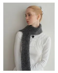 Detailopname van grijze alpaca wollen sjaal met zachte gebreide textuur op model