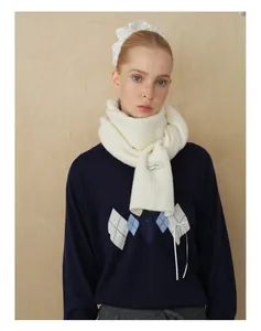 Details des weißen Strickschals aus Wollmischung mit blauem Argyle-Strickpullover kombiniert