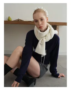 Detail eines weißen Wollmischung-Strickschals mit Winteretikett und feinem Webmuster