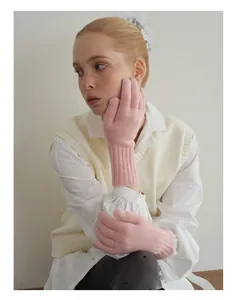 Pink knit wool gloves featuring long ribbed cuffs and a warm, minimalist aesthetic