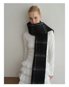 Detailed texture of thick black and grey plaid wool blend scarf on female model