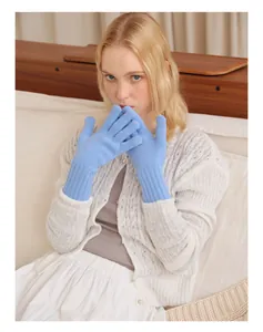 Close-up of light blue pure wool knitted gloves with ribbed cuffs on model's hands