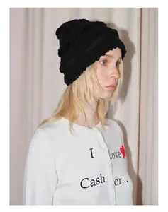 Détail du bonnet en maille mélangée laine noire avec texture ondulée et dentelle