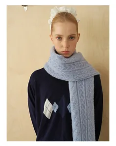 Detail of light blue cable knit wool blend scarf with soft brushed texture and thick weave