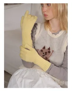 Detailed close-up of yellow knit wool gloves with ribbed cuffs and soft texture