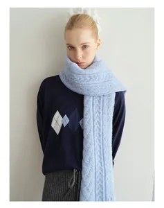 Detail of light blue cable knit wool blend scarf showing thick soft woven texture