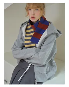 Detail of colorful striped merino wool scarf styled with a grey oversized hoodie