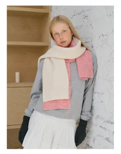 Detail of soft knit wool blend scarf in pink and cream color block texture
