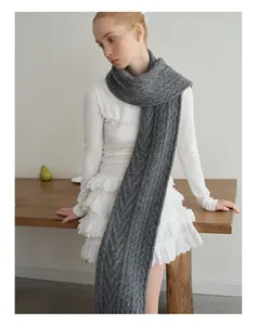 Detail of grey cable-knit wool scarf showing chunky texture and soft vintage weave