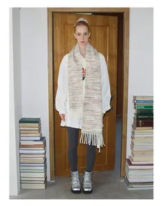 Detailed view of a soft wool blend gradient scarf with tassels and chunky knit texture