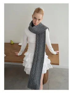 Detail of grey wool blend knit scarf featuring classic chunky cable stitch pattern