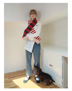 Classic red and black striped merino wool scarf styled with a white sweater and jeans