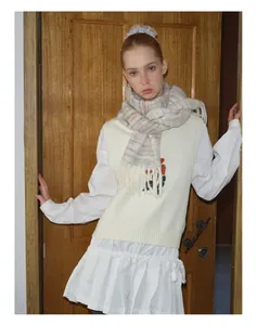 Detail of wool gradient tassel scarf styled with floral embroidered vest and white shirt