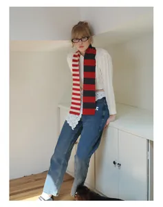 Detailed view of red and black striped merino wool skinny scarf with knit cardigan