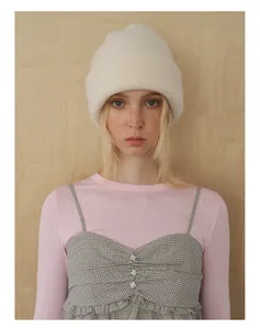 Detail of soft cream wool knit beanie showing thick ribbed texture and folded cuff style