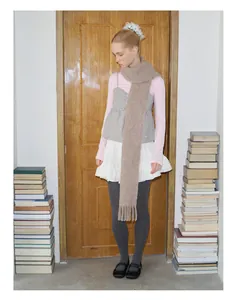 Frau im Vintage-Stil mit einem langen, kamelfarbenen Alpaka-Wollschal mit Fransen
