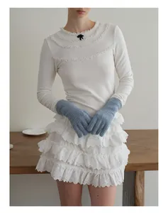 Dettaglio dei guanti blu in misto lana di coniglio abbinati a un outfit di pizzo