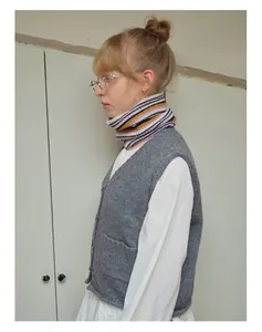 Close-up of wool-blend striped knitted neck warmer with grey v-neck vest and white shirt