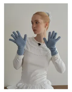 Dettaglio guanti in maglia di lana celeste con fessure per dita touch screen