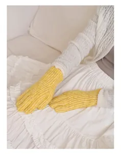 Nahaufnahme hellgelber Strickhandschuhe aus Wollmischung mit warmen Rippbündchen