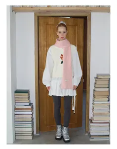 Nahaufnahme eines rosa gerippten Wollschals kombiniert mit einem Winteroutfit