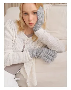 Detail von grauen Grobstrickhandschuhen mit Zopfmuster für warme Winter-Touchscreens