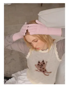Detail of pink knitted raccoon wool gloves with ribbed cuffs and touchscreen function