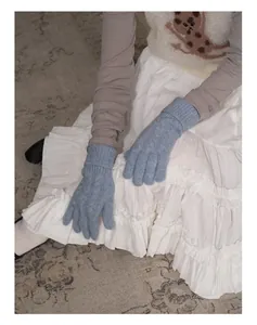 Détail de gants en laine mélangée bleu clair avec maille torsadée et poignets élastiques