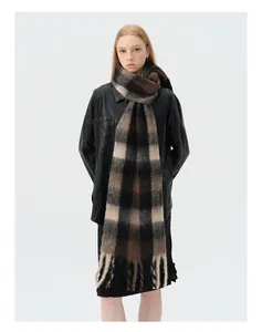 Close-up of thick wool blend plaid scarf in brown and black with soft fringe details