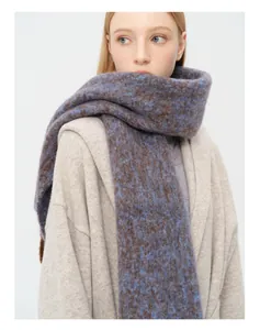 Nahaufnahme eines dicken Alpakawolle-Schals mit blau-brauner Stricktextur und Fransen