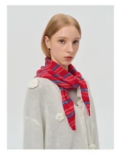 Detail showing wool blend red and blue striped knitted scarf on a model outfit