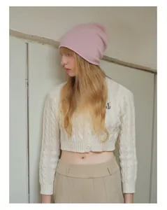Dettaglio berretto in lana australiana rosa chiaro con cardigan in maglia a trecce