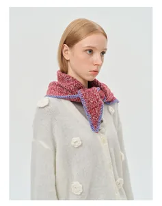 Détail d'un foulard triangle en maille rouge avec bordure crochetée sur gilet blanc