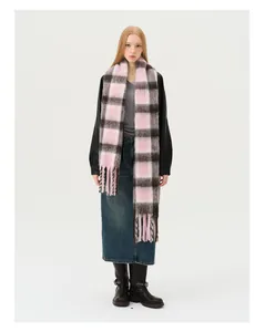 Close-up of pink and brown wool blend plaid scarf with thick fringe and soft texture