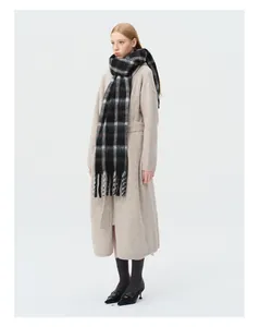 Detail of wool blend plaid scarf with tassels paired with a long oatmeal knit cardigan