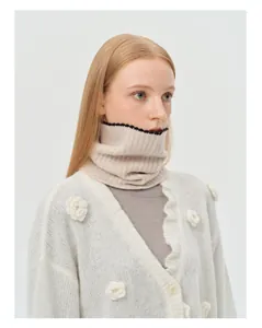 Detail showing the white knitted cardigan with 3D crochet roses and ribbed neck warmer
