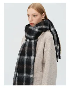 Close-up of thick wool blend scarf with classic black and grey plaid texture
