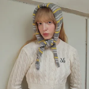 Women's cable knit wool blend cardigan in cream white with a striped knit scarf