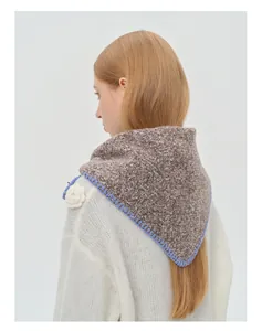 Gros plan détaillé de l'écharpe en tricot marron avec bordure contrastée bleu vif cousue
