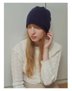 Dettaglio del berretto in lana australiana viola indossato da una modella in inverno